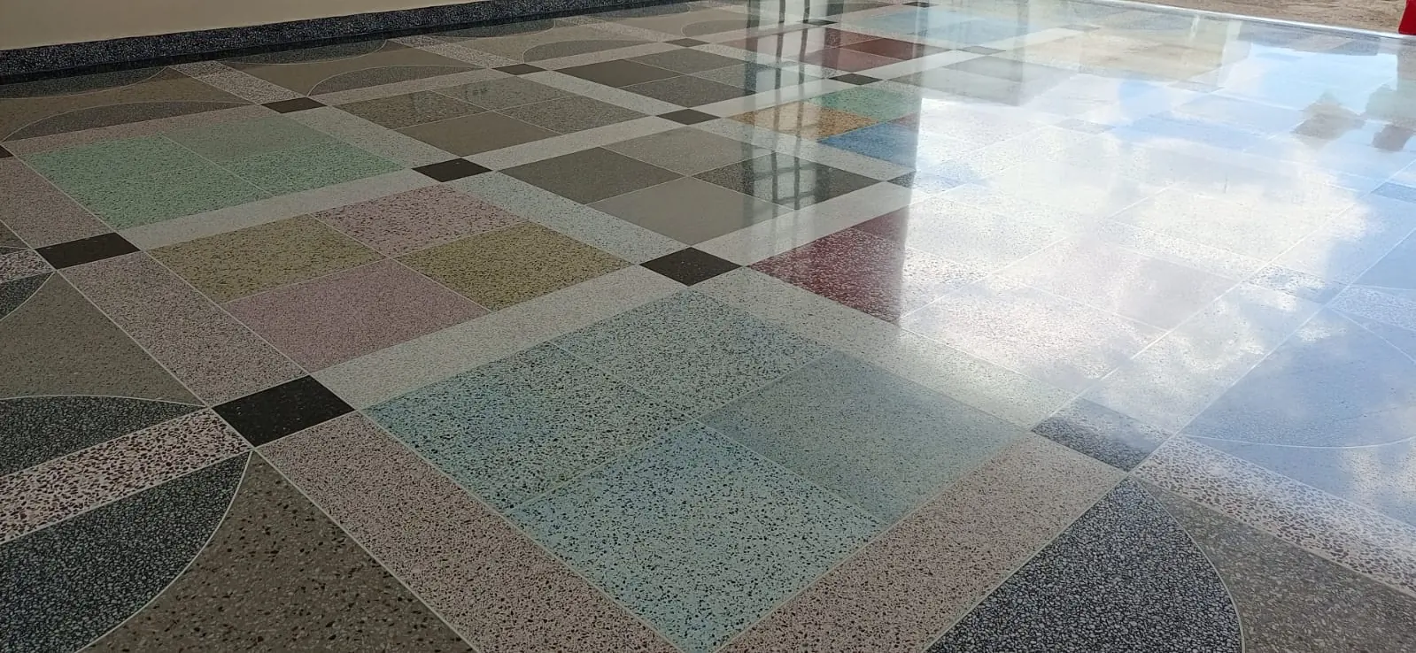Piso de granitina em mosaico colorido refletindo o céu